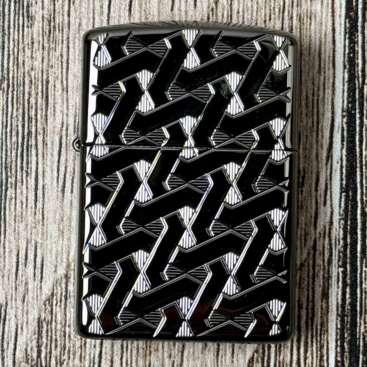 Closed Armor Geometric Weave Zippo with a carved geometric pattern on its dark polished case
