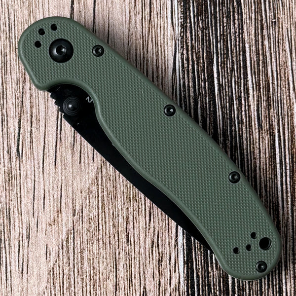 Ontario RAT II folding knife showing its blade, thumb studs, handle scales, and pocket clip